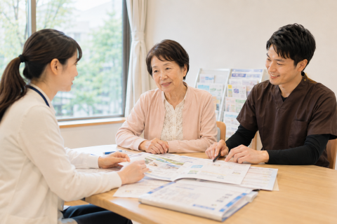 京都市北区の病院で地域連携室の相談員と家族、理学療法士が退院後のリハビリについて相談している様子