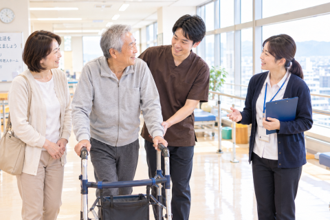 京都市下京区の回復期病院で理学療法士と地域連携室の相談員、家族が退院後の訪問リハビリについて相談している様子